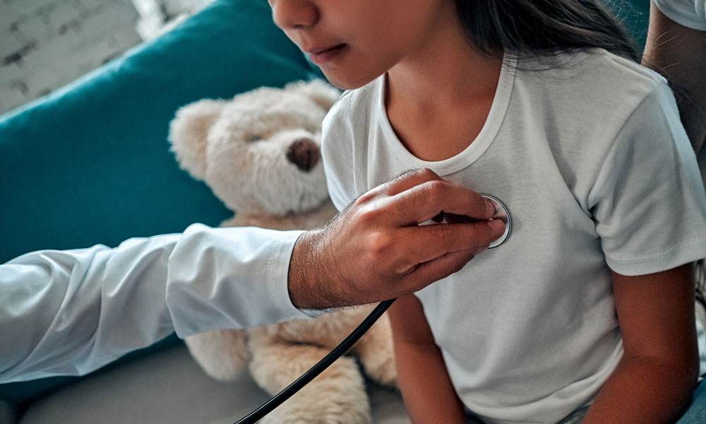 family medicine physician checking child's breathing with stethoscope